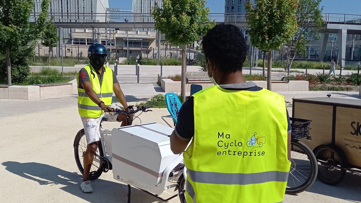 Stagiaires en gilet jaune à vélo cargo pendant une formation